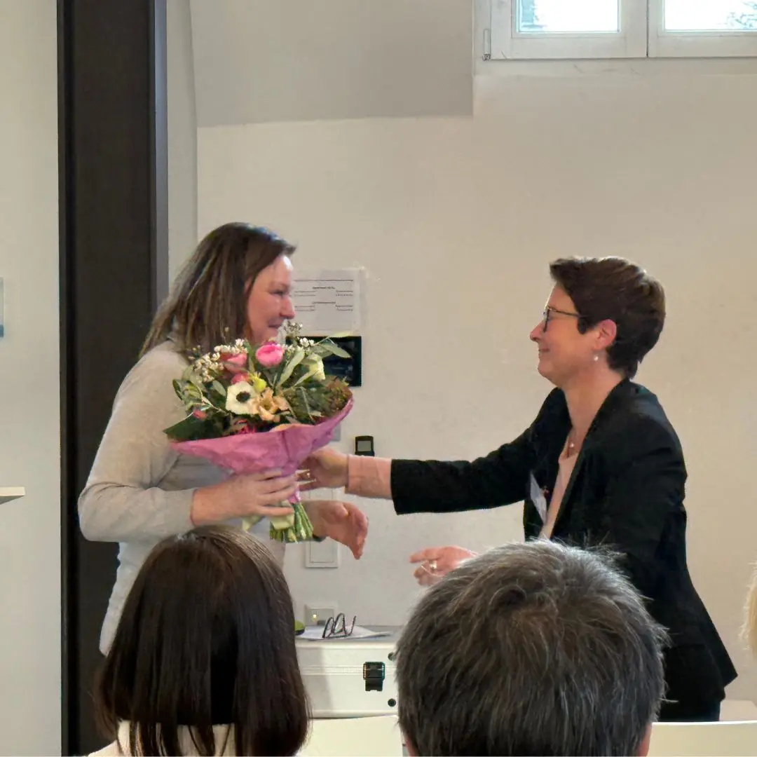 Prof. Dr. Katharina Gröning überreicht Prof. Dr. Heike Friesel-Wark einen bunten Blumenstrauß