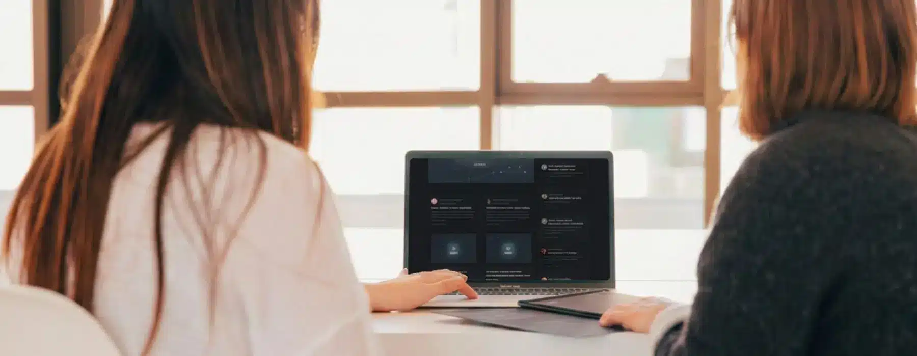 Zwei Frauen sehen sich gemeinsam etwas auf einem Laptop an