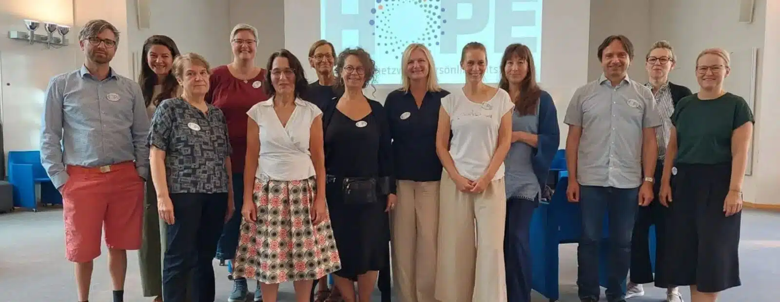 Eine Gruppe von Menschen stehen vor einer Präsentation auf der groß "HOPE" steht