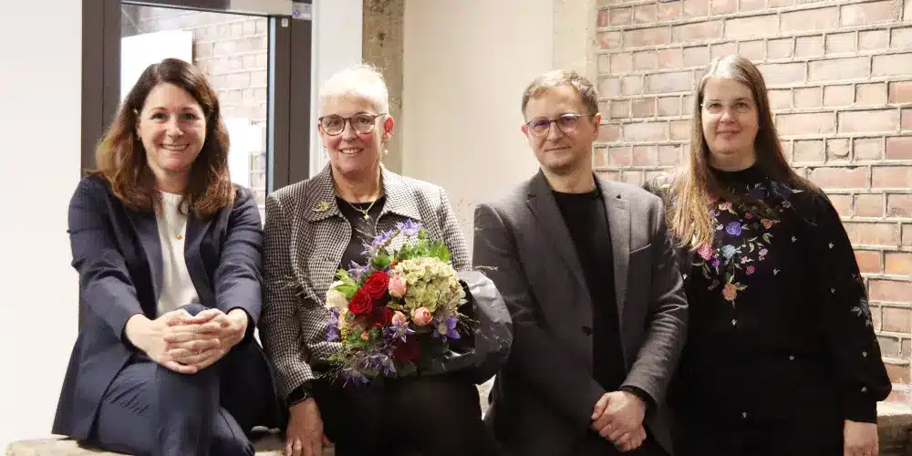 Kanzlerin Judith Topp, Rektorin Prof. Dr. Susanne Kröhnert, Prorektor Prof. Dr. Michael Pawicki und Prorektorin Prof. Dr. Sonja Damen stehen gemeinsam im Foyer der Fliedner Fachhochschule. Die neue Rektorin Prof. Dr. Susanne Kröhnert hält einen Blumenstrauß.