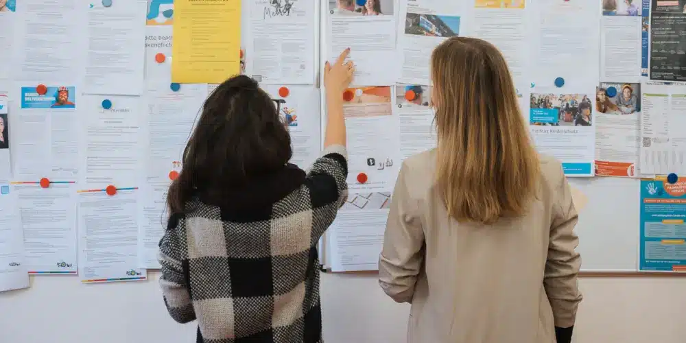 Student:innen stehen vor einem Infoboard